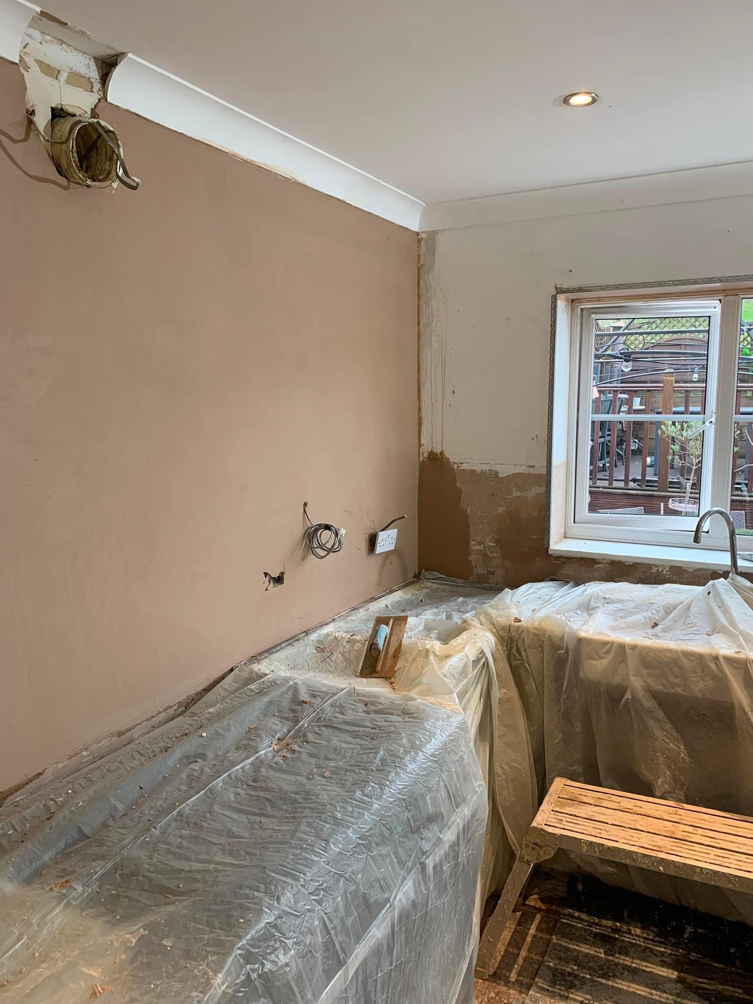 Freshly skimmed lounge wall with carpets and furniture sheeted over